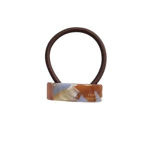 Elegant tortoiseshell acetate hair tie with golden logo and curved geometric design