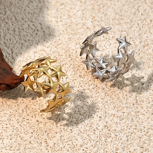 Minimalist gold and silver star cutout open rings displayed on natural stone