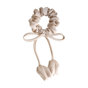 Minimalist beige satin hair scrunchie with long ribbons and floral tassels on white background