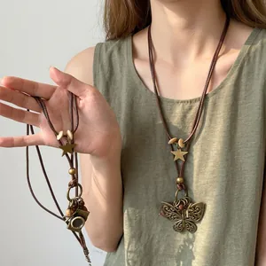 Collier bohème vintage avec pompons fleurs et perles en bois sur cordon marron