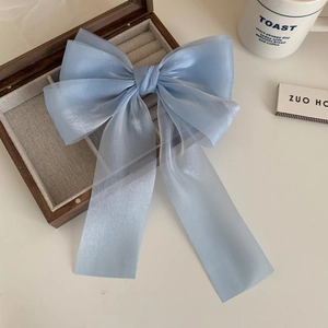 Detail of light blue mermaid bow hair clip on a wooden box with a cozy morning setup