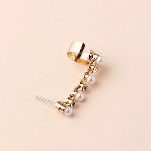 Elegant gold-plated ear cuff with pearls and diamonds on a clean beige background