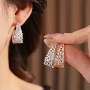 Orecchini a cerchio a U placcati in oro 18k con zirconi incastonati indossati da una modella