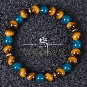 Macro shot of tiger eye and turquoise beads with retro bronze spacers on black background