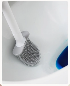 Detail of grey silicone toilet brush head cleaning inside bowl with blue liquid
