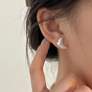 Detailed view of sterling silver croissant stud earring on model for minimalist style