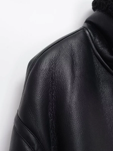Gros plan sur la couture de l'épaule et la texture du cuir noir de la veste