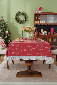 Close-up of red cotton Christmas tablecloth featuring white reindeer and ruffle hem details