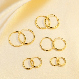 Five pairs of golden S925 sterling silver hoop earrings in multiple sizes on silk