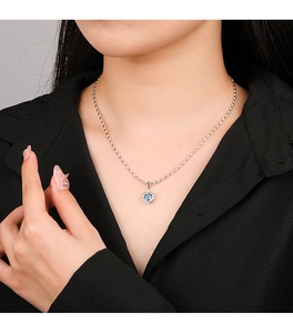 Close-up of 925 sterling silver heart necklace with a translucent blue gemstone pendant