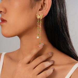 Elegant butterfly tassel earrings with green beads and pearls on professional model