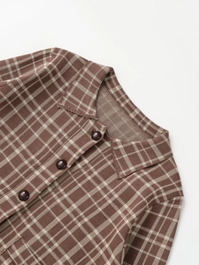 Detailed view of the brown plaid knit collar and resin button on the stylish jacket