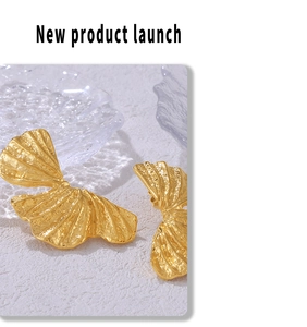 Macro shot of gold leaf earrings with textured finish and organic petal design details