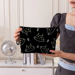 Handheld black cat makeup bag with white line drawings and convenient wrist strap