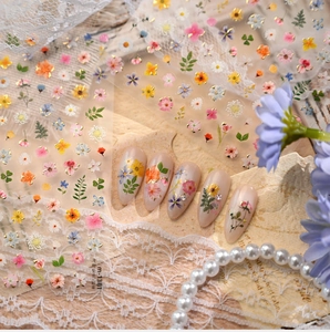 Detailed view of floral nail art stickers applied on elegant almond-shaped nails.