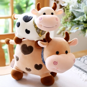 Lindos peluches de vacas con manchas de corazón y bufandas de cuadros en un hogar cálido