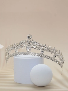 Close-up of vintage bridal crown with silver leaf patterns and crystal embellishments