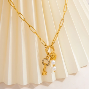 Gold stainless steel necklace featuring a rhinestone heart key and elegant pearl charms