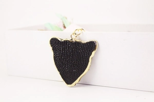 Close-up of black leopard head keychain with gold trim and rhinestones on white box