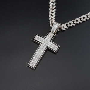 Close-up of hip-hop cross pendant with shiny rhinestones and thick cuban chain
