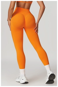 Detailed back view of high-waisted seamless scrunch butt yoga leggings in bright orange