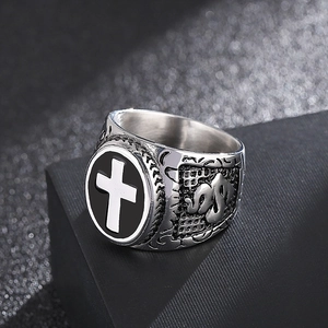 Macro detail of retro stainless steel ring with black cross and vintage embossed patterns