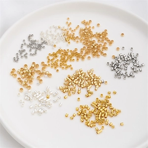 Mix of 14K gold filled and silver crimp beads for DIY jewelry making in a white bowl