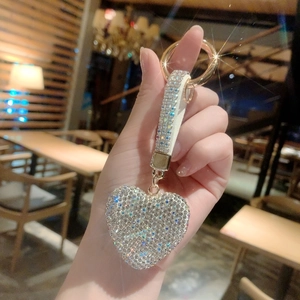 Close-up of sparkling rhinestone heart keychain with white diamond-studded strap