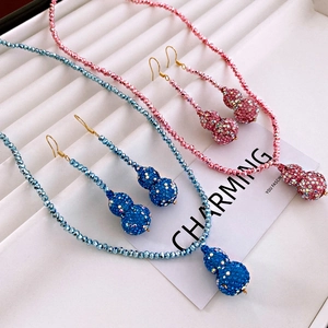 Detail of luxury rhinestone gourd jewelry set in pink and blue colors on white backdrop