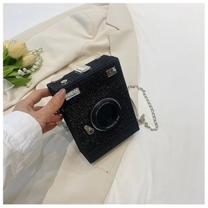 Detail of a black sequined camera-shaped crossbody bag with a metallic chain strap