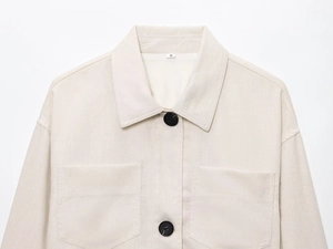 Détail d'une veste chemise en mélange de lin beige avec poches poitrine et boutons noirs