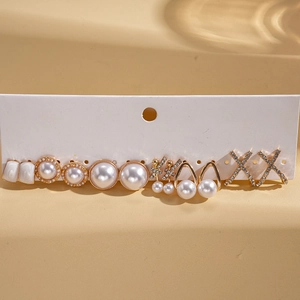 Dettaglio di un set di 6 paia di orecchini con perle e strass su cartoncino bianco