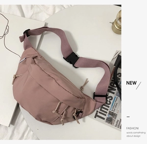 Nylon sling bag in dusty rose color with multiple zipper pockets and adjustable buckle