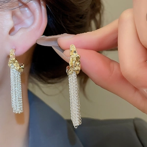 Detailed shot of French retro C-shape earrings with silver tassels and gold irregular texture