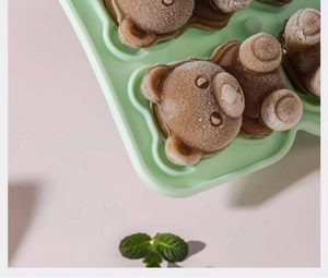 Detail of light green silicone bear mold with frozen brown bear-shaped ice cubes inside