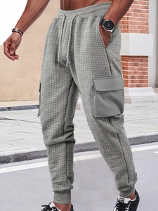 Detail of grey waffle-knit cargo joggers with large side pockets and drawstring waist