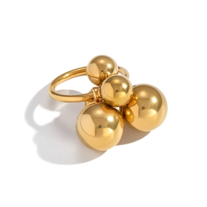 Detailed view of polished golden metal ring with four spheres in different sizes