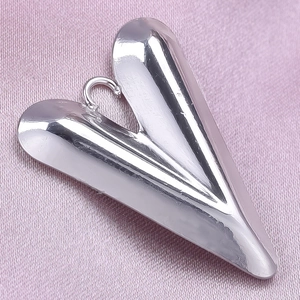 Polished 304 stainless steel heart pendant on soft pink silk fabric background