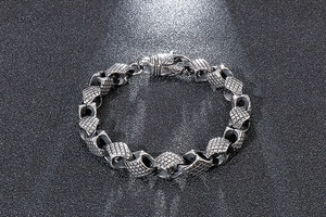 Close-up of retro geometric link texture and sturdy clasp on stainless steel men's bracelet