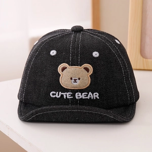 Détail de casquette en jean pour bébé avec patch ours mignon et surpiqûres blanches