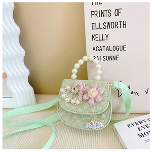 Detail of mint green lace crossbody bag with pearl handle and plush flower decor
