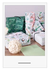 Close-up of jungle-themed gift wrapping paper with tropical animal patterns and ribbons
