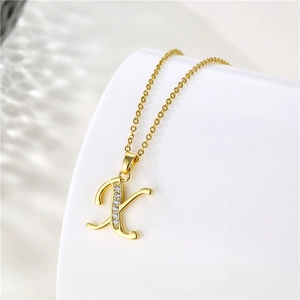 Detail of 18K gold plated X-letter pendant necklace with sparkling zircon inlay