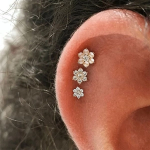 Detailed close-up of S925 silver flower stud earrings with pearls and zircon on model ear