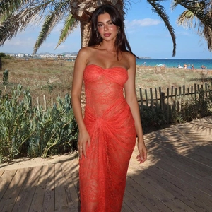 Macro detail of red lace mesh dress with pleated texture on a beach boardwalk