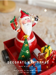 Detail of metal Christmas sleigh set with Santa, LED lights and festive gift box ornaments