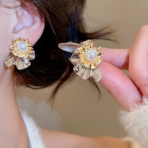 Macro detail of multilayer flower earrings with pearls and vintage silver finish