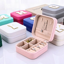 Macro detail of various colorful jewelry boxes showing chenille embroidery and zip closure