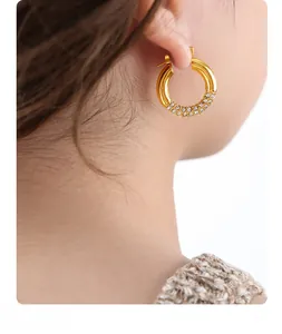 Detail shot of gold-plated hoop earrings with micro-pave cubic zirconia on a model
