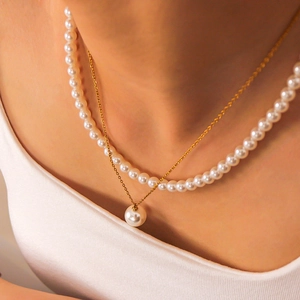 Elegant double-layered pearl necklace with gold chain pendant shown on model neck